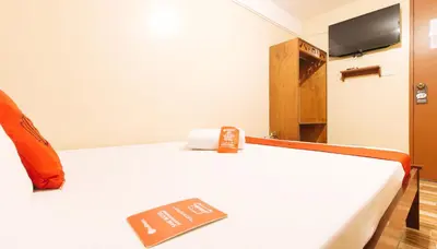 a room with a bed with a sign on it at RedDoorz near PNR Espana Station in Manila