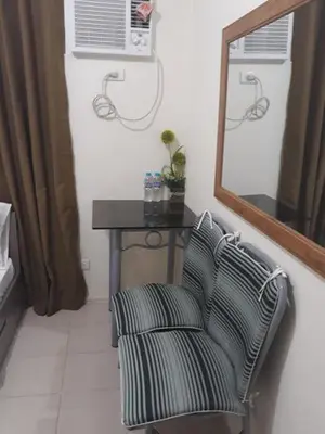 a room with a table and a chair and a mirror at Edsa Urban Deca Tower Condo Unit with Wifi and Netflix in Manila