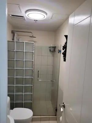 a bathroom with a shower and a toilet at Juja's place in Manila