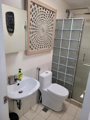 a bathroom with a toilet and a sink and a shower at Juja's place in Manila