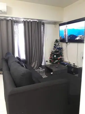 a living room with a couch and a christmas tree at Cucun's place in Manila