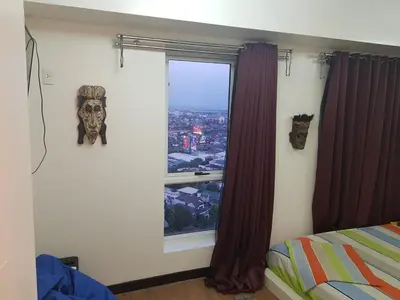 a bedroom with a window with a skull on the wall at Cucun's place in Manila