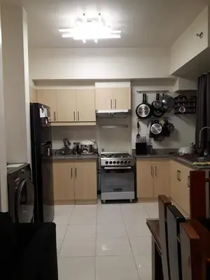a kitchen with wooden cabinets and a stove at Cucun's place in Manila