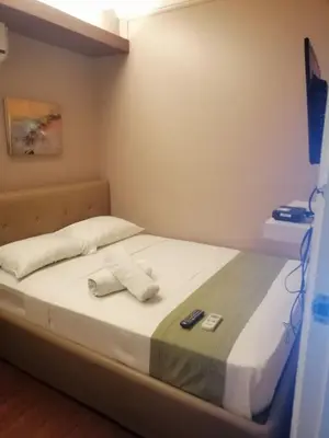 a bed in a room with two remote controls on it at ANNELENA INN in Manila