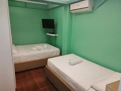a small room with two beds and a tv at ANNELENA INN in Manila