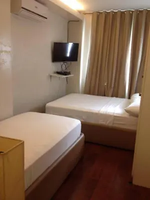 a hotel room with two beds and a television at ANNELENA INN in Manila