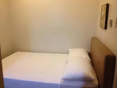 a small bedroom with a bed with white sheets at ANNELENA INN in Manila