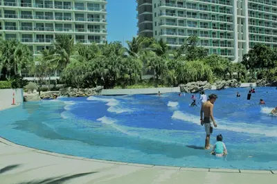 a group of people in a large pool with blue water at Azure C2 Balcony wifi Near Mall Airport MULTIPLE UNITS in Manila