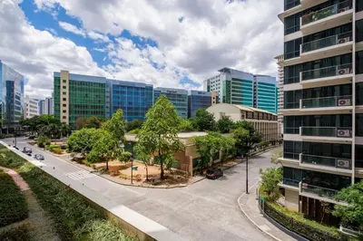 an empty street in a city with tall buildings at Modern Stylish Condo in Morgan Suites McKinley with Wi-Fi in Manila