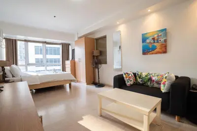a living room with a couch and a bed at StayHere BGC City Studio in SOMA near SM Aura in Manila