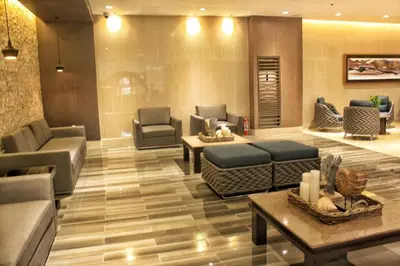 a lobby with couches and tables in a building at A SPECIAL PLACE Shore Residences in Manila