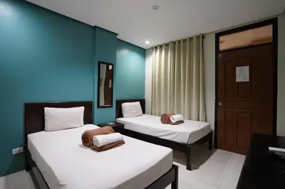 two beds in a room with blue walls at Arzo Hotel Grand Lodge in Manila
