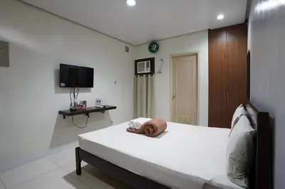 a bedroom with a bed with a towel on it at Arzo Hotel Grand Lodge in Manila