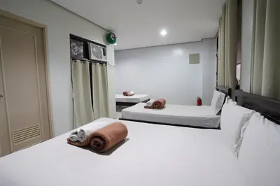 a hotel room with two beds with towels on them at Arzo Hotel Grand Lodge in Manila
