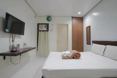 a hotel room with a bed with a towel on it at Arzo Hotel Grand Lodge in Manila