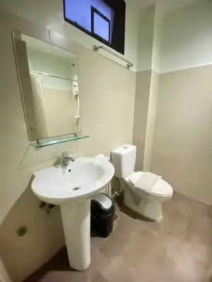a white bathroom with a sink and a toilet at Arzo Hotel Grand Lodge in Manila