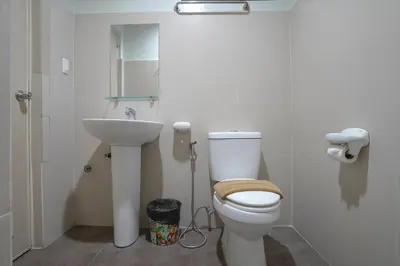 a bathroom with a toilet and a sink at Arzo Hotel Grand Lodge in Manila
