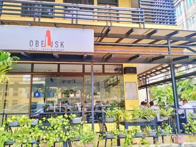 a restaurant with a sign on the side of a building at Arzo Hotel Grand Lodge in Manila