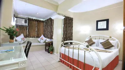 a hotel room with a bed and a bath tub at Loreland Farm Resort in Antipolo
