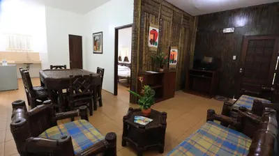 a living room with chairs and a table and a dining room at Loreland Farm Resort in Antipolo