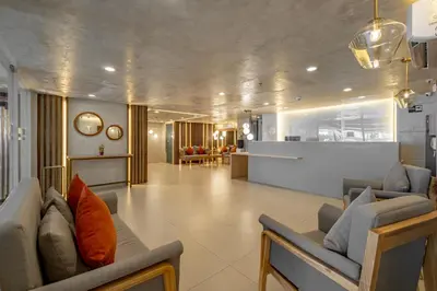 a living room with two couches and a kitchen at iHotel Uptown BGC in Taguig