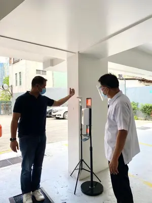 two men wearing masks standing next to a building at iHotel Uptown BGC in Taguig