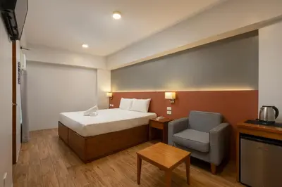 a hotel room with a bed and a chair at iHotel Uptown BGC in Taguig