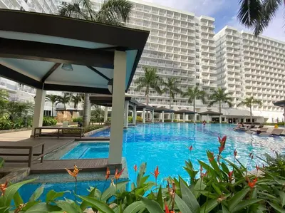 a large swimming pool in front of a large building at Cozy Space at Shell Residences in Tower A in Manila