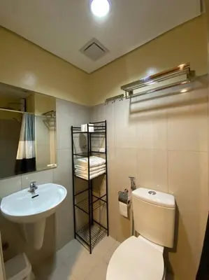 a bathroom with a white toilet and a sink at Cozy Space at Shell Residences in Tower A in Manila