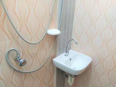 a bathroom with a sink and a stethoscope on a wall at JB Valdres Apartment in Manila
