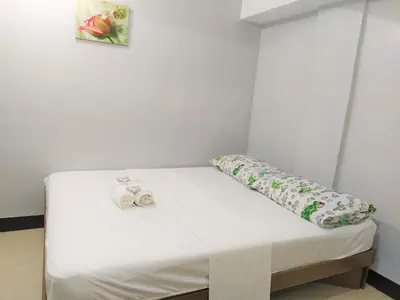 a bed in a room with two towels on it at JB Valdres Apartment in Manila