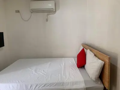 a bed in a room with a red pillow at Lucky Hotel Binondo in Manila
