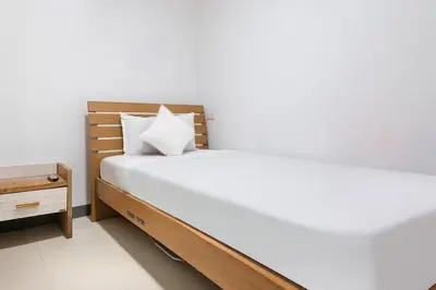 a bedroom with a large bed and a night stand at Lucky Hotel Binondo in Manila