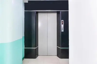an elevator with a white door in a building at Lucky Hotel Binondo in Manila