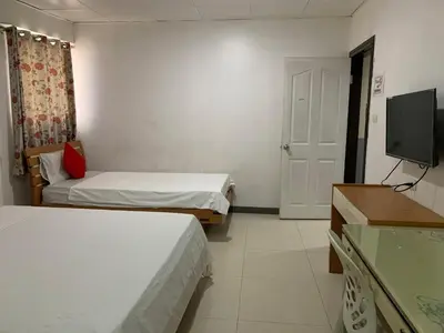a hotel room with two beds and a television at Lucky Hotel Binondo in Manila