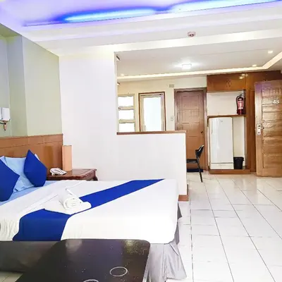 a hotel room with a bed and a table at Alley 8 Makati in Manila