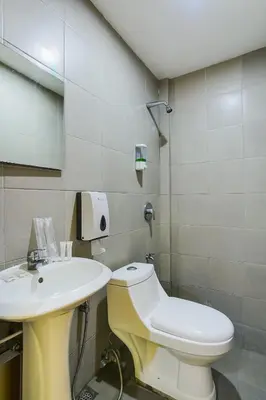a bathroom with a white toilet and a sink at OYO 473 Ranchotel Drive-in in Biñan