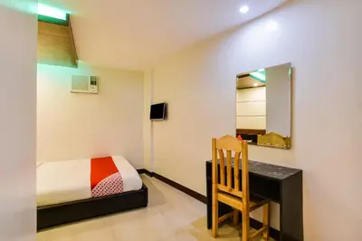 a bedroom with a desk and a bed and a mirror at OYO 473 Ranchotel Drive-in in Biñan