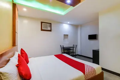 a bedroom with a bed with red pillows at OYO 473 Ranchotel Drive-in in Biñan