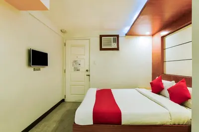 a bedroom with a large bed with red pillows at OYO 473 Ranchotel Drive-in in Biñan