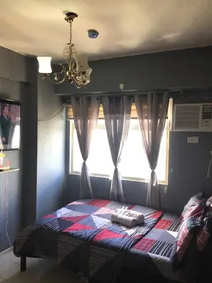 a bedroom with a bed with a window and a chandelier at Booker Com in Mandaluyong in Manila