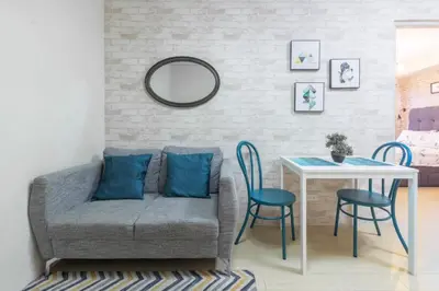 a living room with a couch and a table at 1BR Interiored Condo with WiFi, Netflix, Hot Shower - The Hive Residences in Taytay