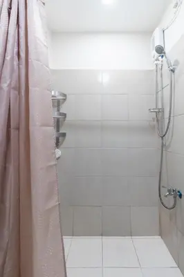 a bathroom with a shower with a shower curtain at 1BR Interiored Condo with WiFi, Netflix, Hot Shower - The Hive Residences in Taytay
