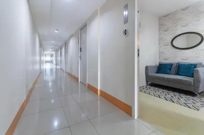 a hallway with a couch and a mirror on a wall at 1BR Interiored Condo with WiFi, Netflix, Hot Shower - The Hive Residences in Taytay