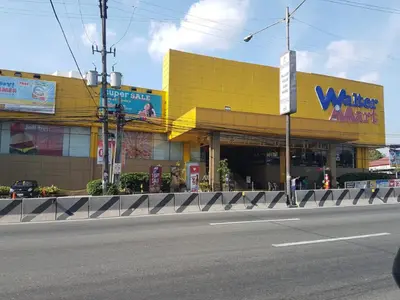 a yellow building on the side of a street at 1BR Interiored Condo with WiFi, Netflix, Hot Shower - The Hive Residences in Taytay