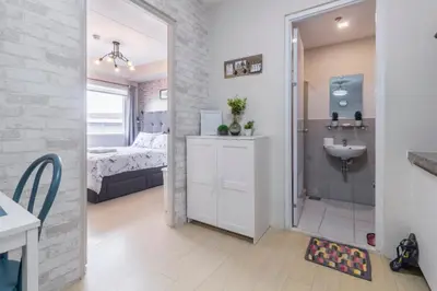 a bathroom with a shower and a sink and a bedroom at 1BR Interiored Condo with WiFi, Netflix, Hot Shower - The Hive Residences in Taytay