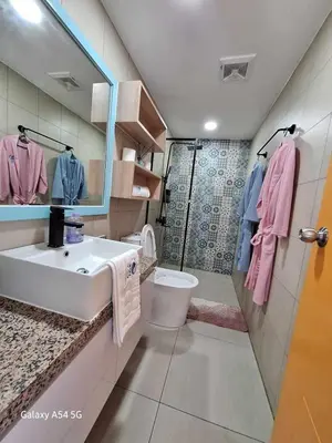 a bathroom with a sink and a toilet and a mirror at Manila Urban Resort at Azure in Manila