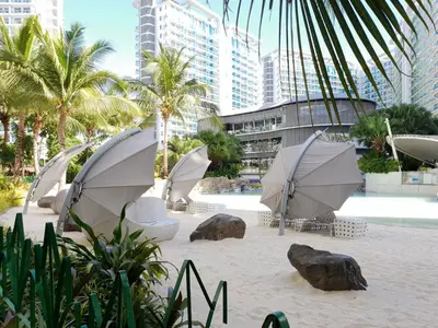 a group of umbrellas on a beach with buildings at Manila Urban Resort at Azure in Manila