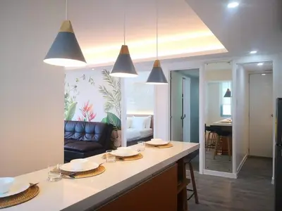 a kitchen and living room with a table and a couch at Manila Urban Resort at Azure in Manila