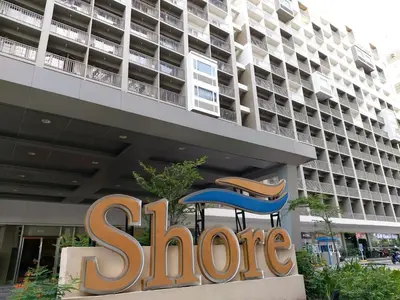 a sign for a store in front of a building at Tower C Shore Residences by CSLUXE in Manila